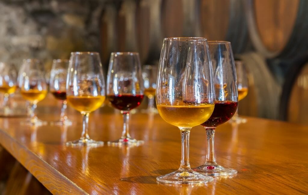 Bar en bois avec une longue rangée de petits verres à porto aux portos rouges et blancs