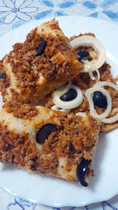 une part de pizza méditerranéenne aux sardines