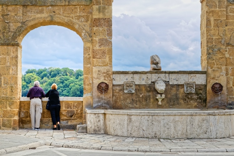 Pareja de ancianos viendo la vista desde el pueblo de pitigliano, toscana