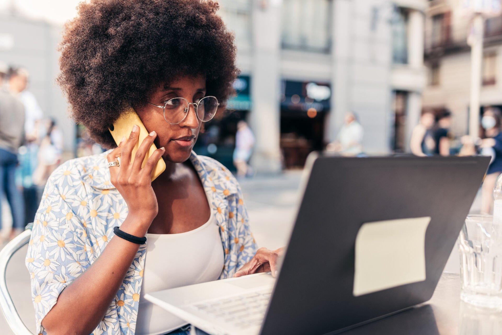 Femme africaine travaillant à distance sur la terrasse du bar