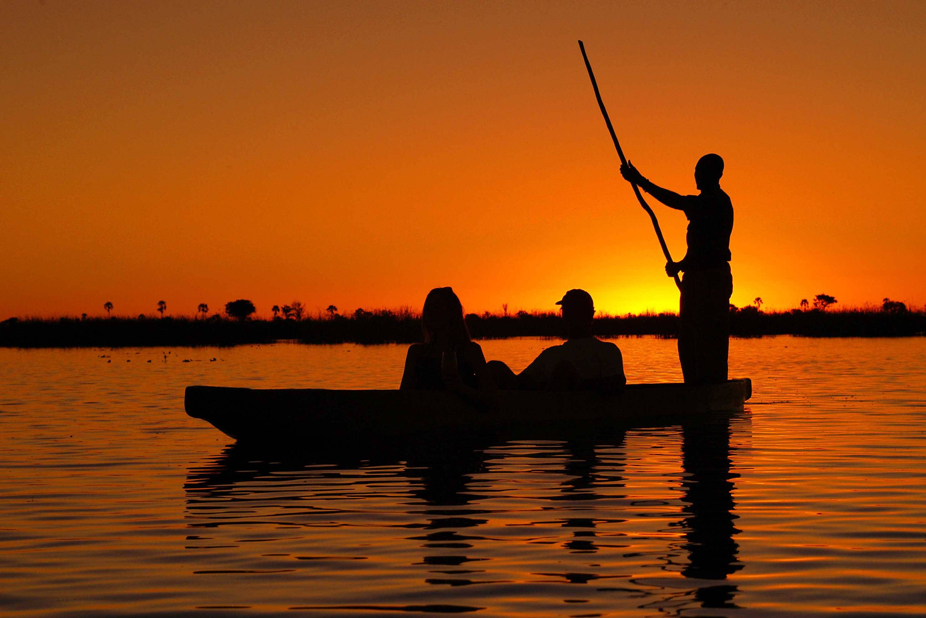 Sunset-mokoro-Paseo-sur-lelta-del-okavango Mokoro marchant au coucher du soleil dans le delta d'Okavango