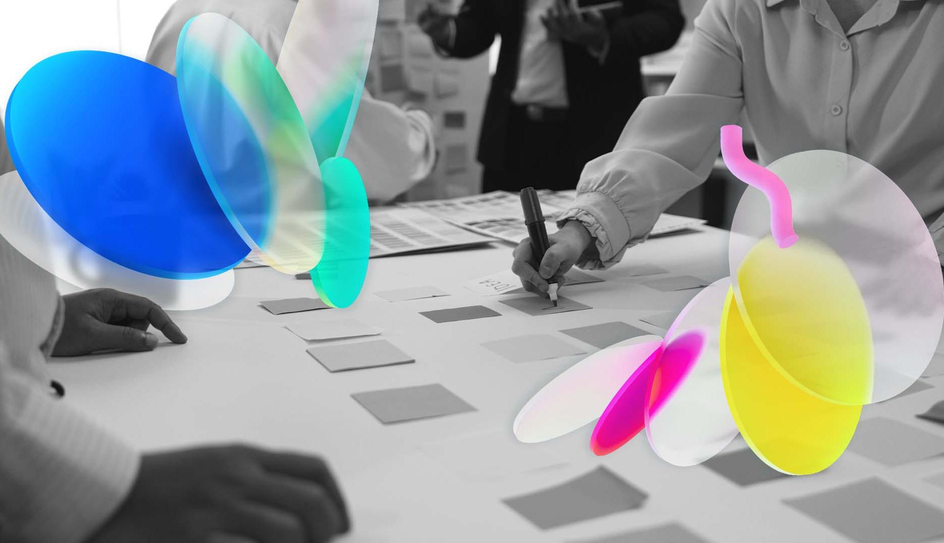 unas manos escribiendo y dibujando en una mesa colaborativa