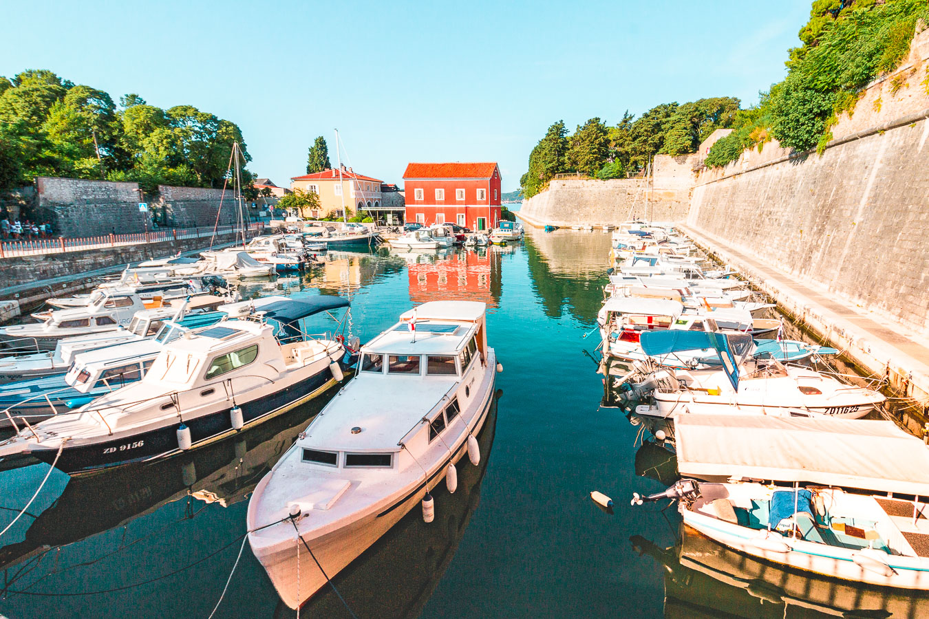 Cette image montre des bateaux de pêche dans les canaux qui bordent les murs de la ville. 