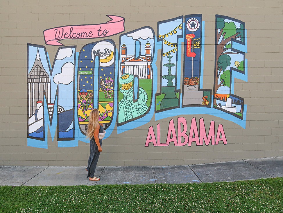 Alex devant une fresque qui dit 