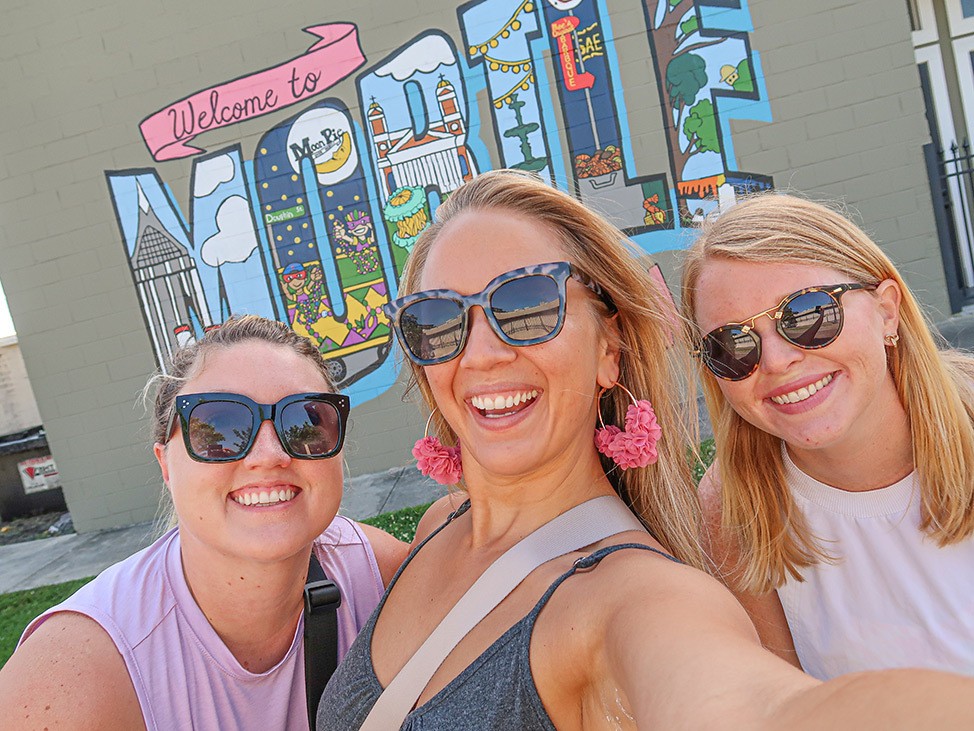 Katie, Alex et Catherine avant la fresque murale Welcome to Mobile