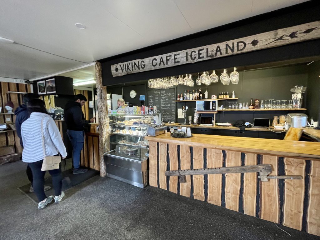 Une caissière de café avec une pancarte en bois sur le mur indiquant VIKING COFFEE ICELAND.