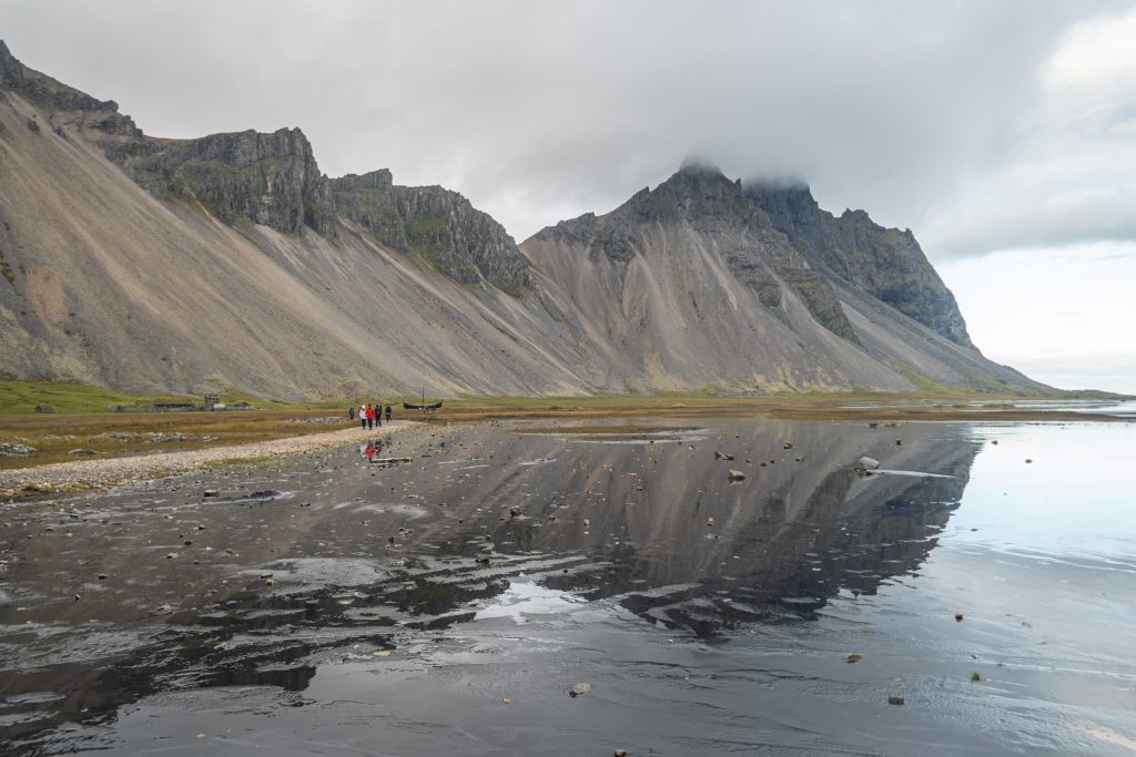 Un pinacle gris qui se reflète dans l'eau calme.