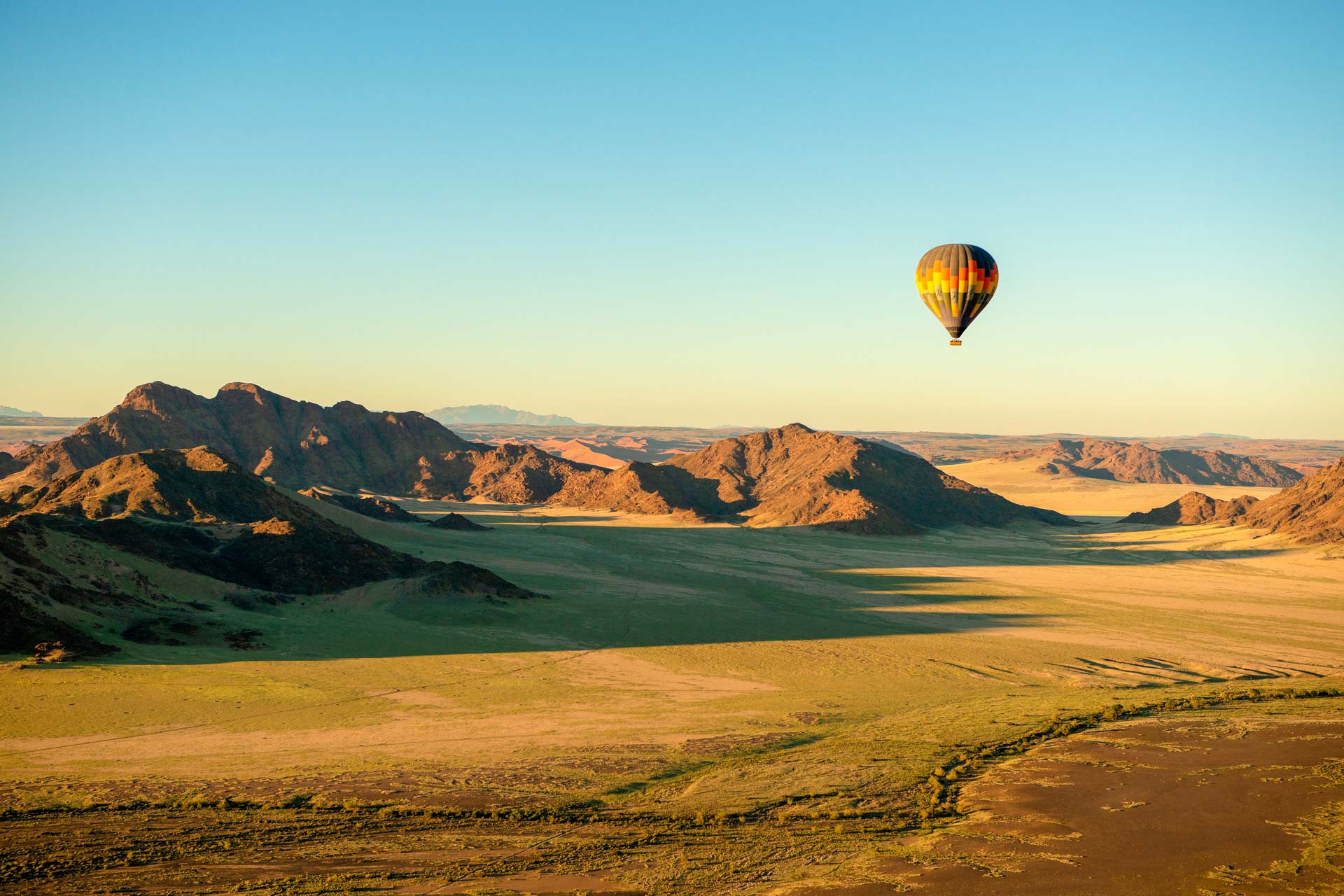 Un vol en montgolfière dans le parc national de Sossusvlei-paysage-lever du soleil-Namibie-AdobeStock_477579616 Vol en montgolfière au-dessus du paysage du parc national de Sousse au Sri Lanka au lever du soleil.