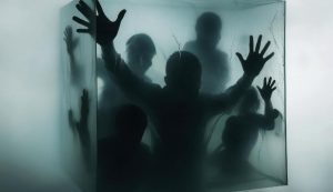 Sombras de personas dentro de un cubo de cristal, intentando salir
